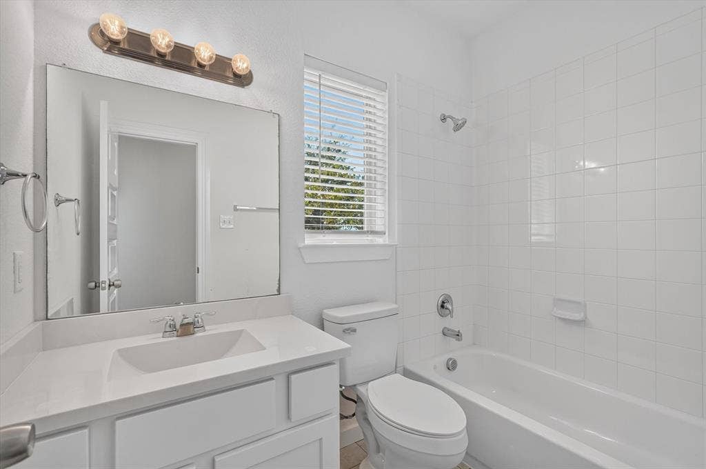 2832 Lolita Way, Forney, TX 75126 Bright and clean bathroom featuring a large framed mirror, white subway tile walls, and a single-basin vanity with ample counter space