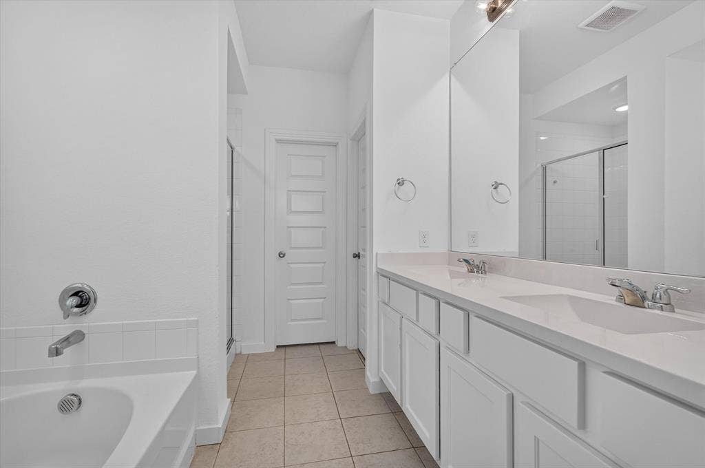 2832 Lolita Way, Forney, TX 75126 Spacious dual-vanity bathroom featuring a long countertop with integrated sinks, chrome fixtures, and ample mirror surface