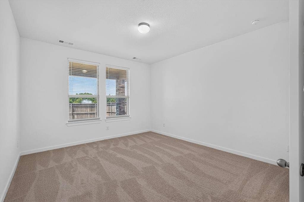 2832 Lolita Way, Forney, TX 75126 Bright bedroom featuring dual windows with natural light, neutral wall finishes, and wood-finish flooring throughout