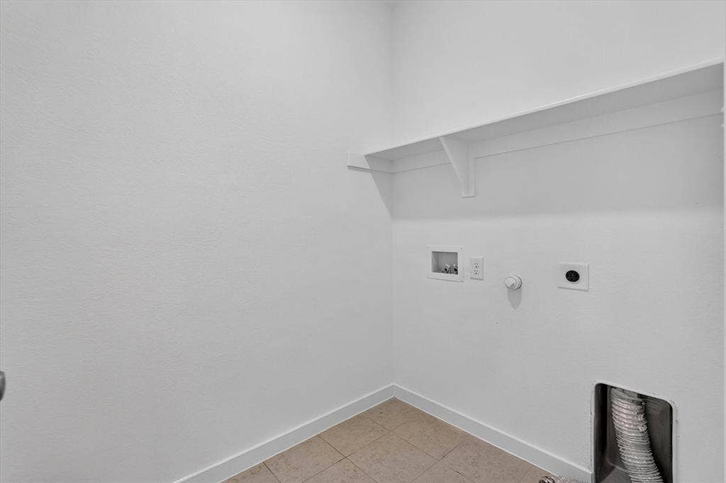 2832 Lolita Way, Forney, TX 75126 Utility room featuring clean white walls, polished concrete flooring, wall-mounted electrical outlets, and built-in shelving with integrated support brackets for efficient storage and organization