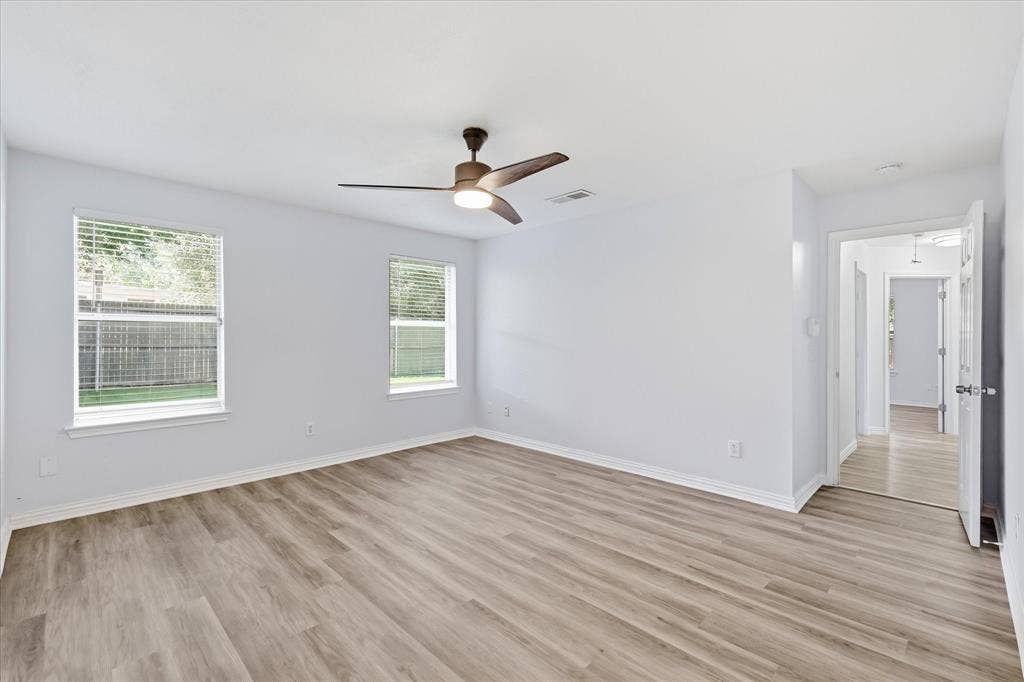 311 Bridlegate Drive, McKinney, TX 75069 Open primary suite with luxury vinyl plank flooring and ample space for a king-sized bed.