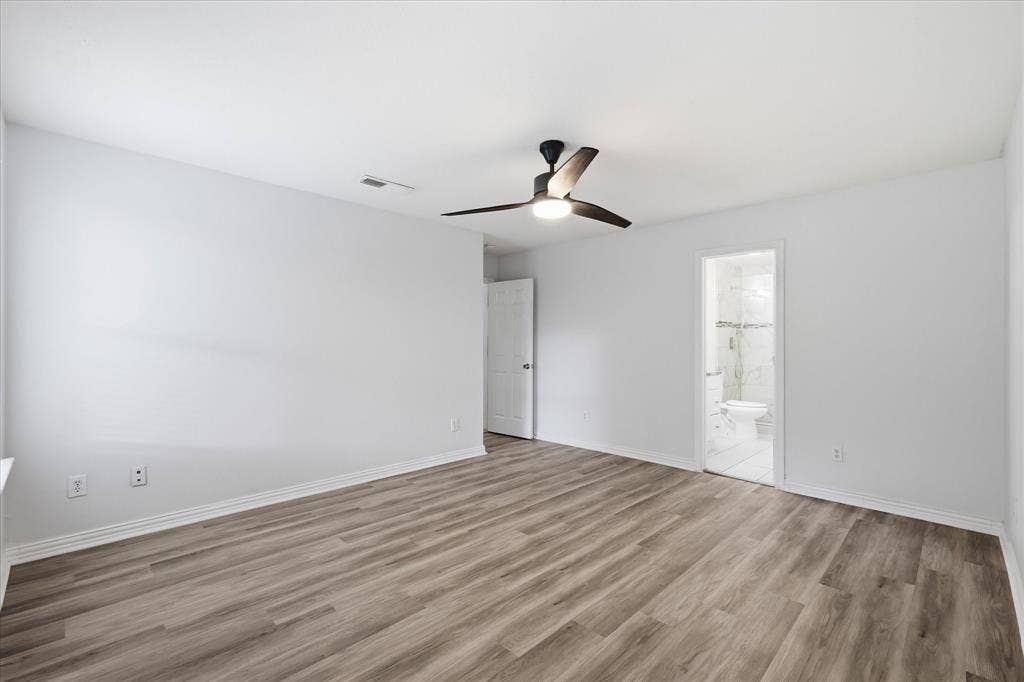 311 Bridlegate Drive, McKinney, TX 75069 Open primary suite with luxury vinyl plank flooring and ample space for a king-sized bed.