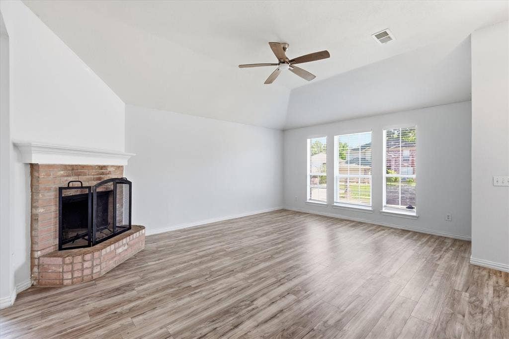 311 Bridlegate Drive, McKinney, TX 75069 Spacious 15x18 living room with high ceilings, a fireplace, and luxury vinyl plank flooring.