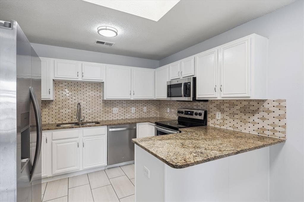 311 Bridlegate Drive, McKinney, TX 75069 Updated open kitchen with granite countertops, stainless steel appliances, and luxury vinyl plank flooring.