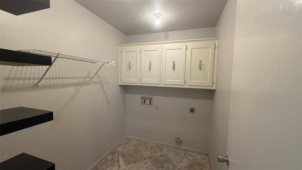 106 E Fairway Drive, Hideaway, TX 75771 Laundry area featuring overhead cabinetry, built-in shelving, a wire rack, and a hard-surface flooring