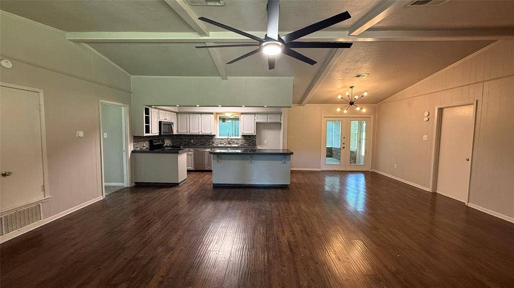 106 E Fairway Drive, Hideaway, TX 75771 Open-concept living area featuring wood-finish flooring, a vaulted ceiling with exposed beams, and a modern ceiling fan