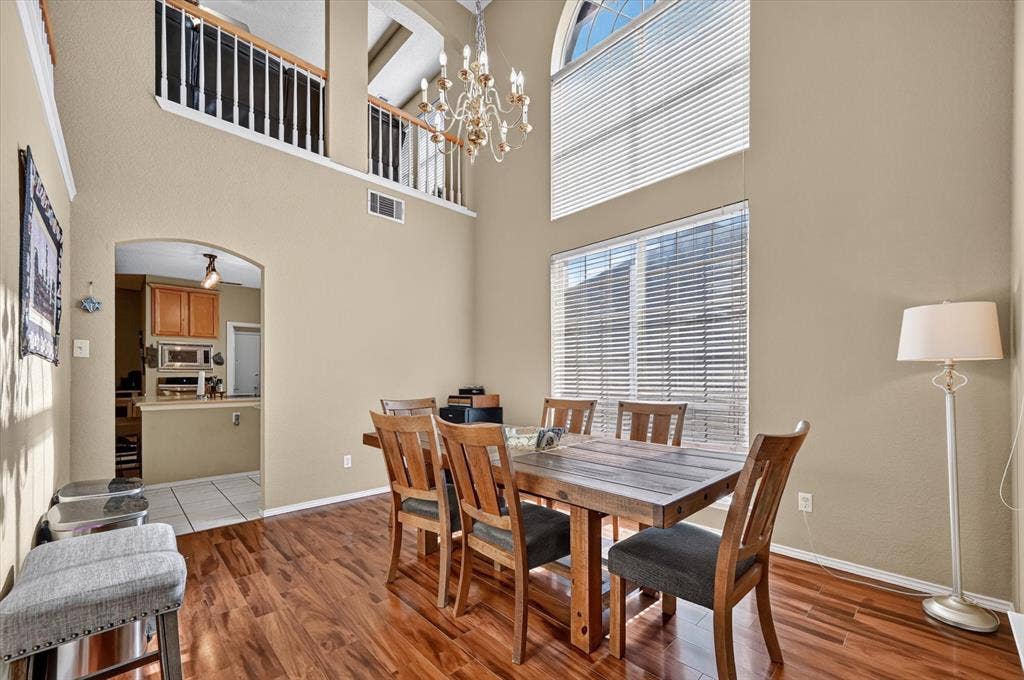 1625 Falmouth Drive, Plano, TX 75025 Two-story dining space featuring wood-finish flooring and a high vaulted ceiling