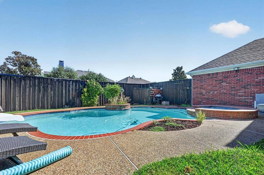 1625 Falmouth Drive, Plano, TX 75025 Backyard entertainment space featuring a swimming pool, integrated spa, and exposed aggregate patio