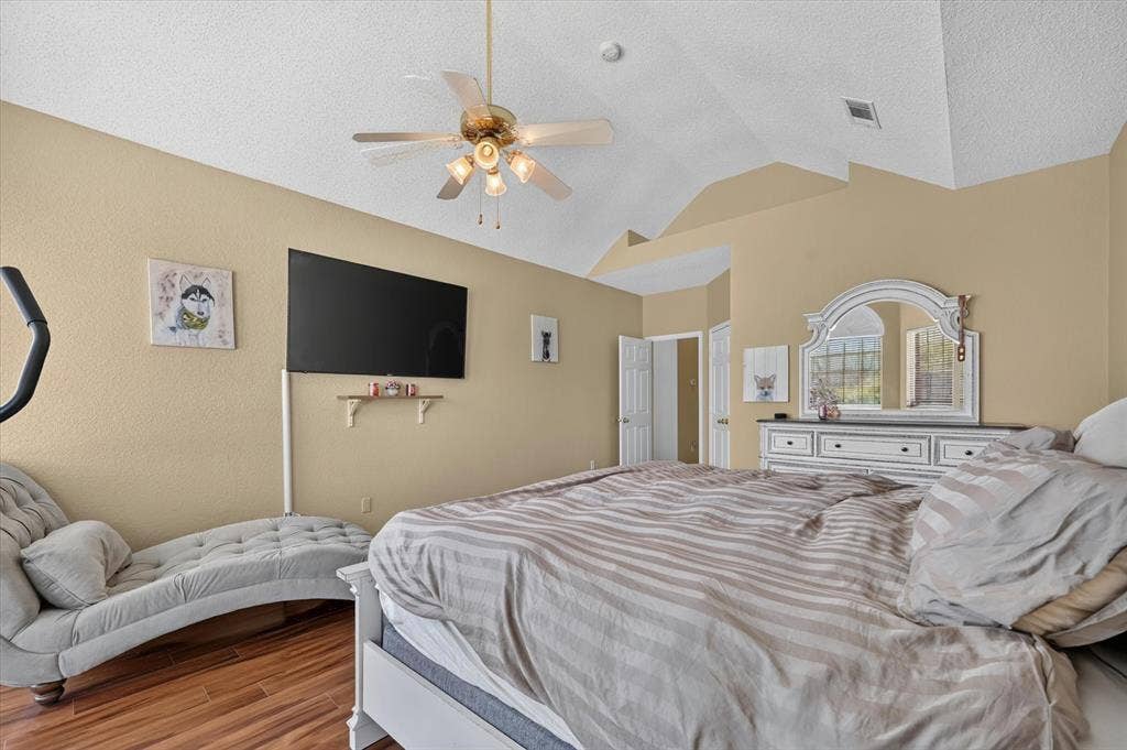 1625 Falmouth Drive, Plano, TX 75025 Room featuring vaulted ceilings, wood-finish flooring, a ceiling fan with integrated lighting, and a neutral wall color