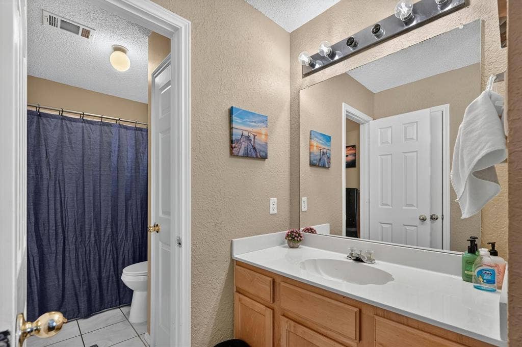 1625 Falmouth Drive, Plano, TX 75025 Bathroom featuring a light wood-finish vanity with a white countertop and integrated sink