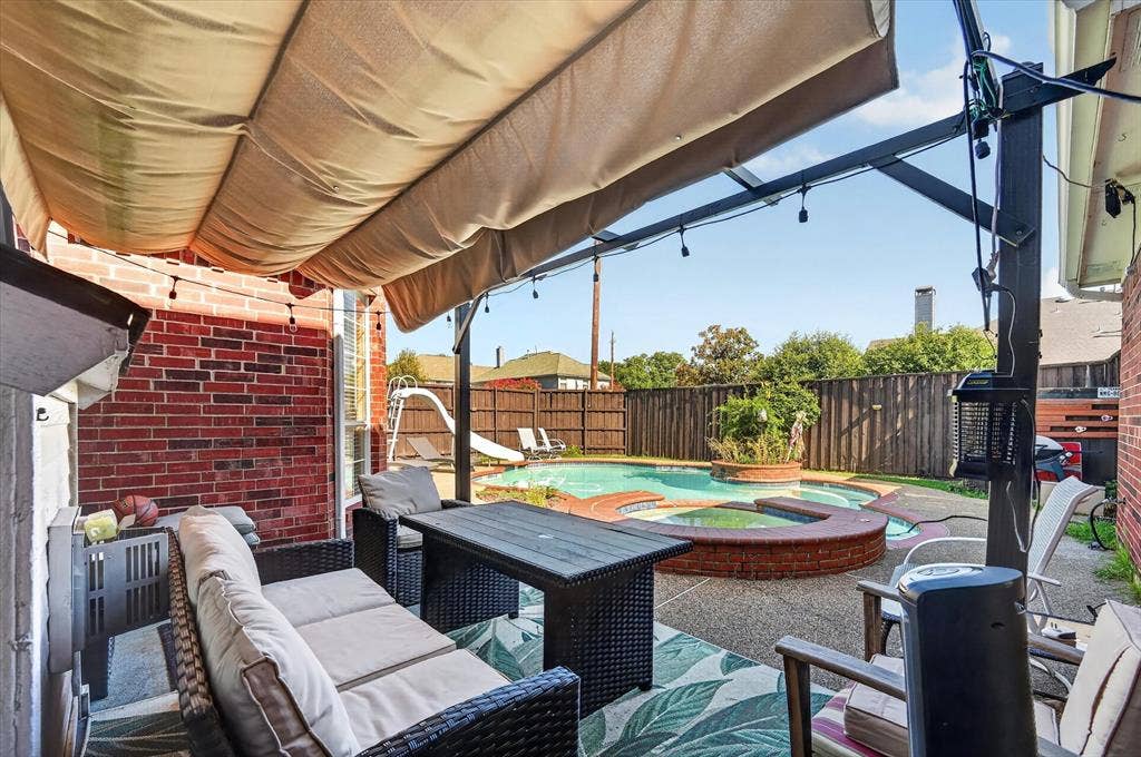 1625 Falmouth Drive, Plano, TX 75025 Covered patio featuring a brick exterior wall, string lighting, and a retractable canopy