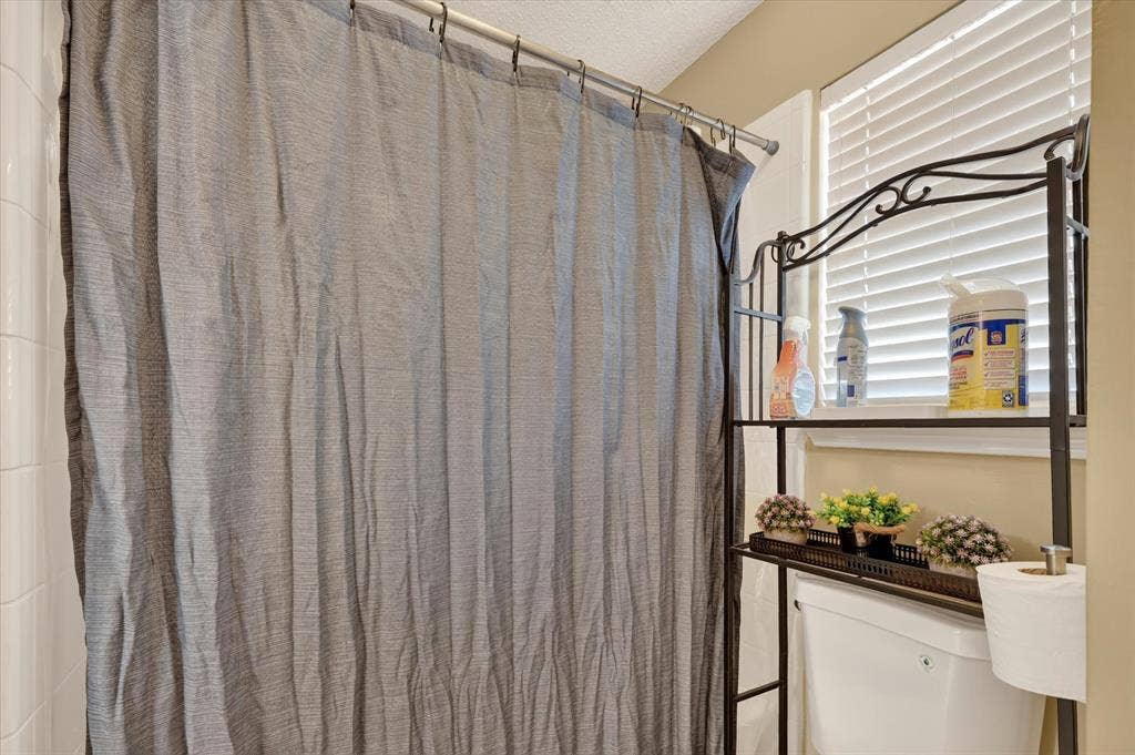 1625 Falmouth Drive, Plano, TX 75025 White tiled shower surround with a metal shower rod