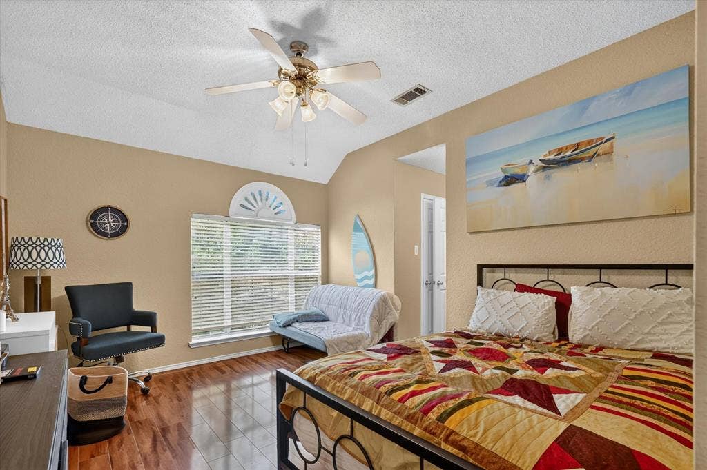 1625 Falmouth Drive, Plano, TX 75025 Vaulted ceiling with a ceiling fan, wood-finish flooring, and a window with blinds and an arched transom