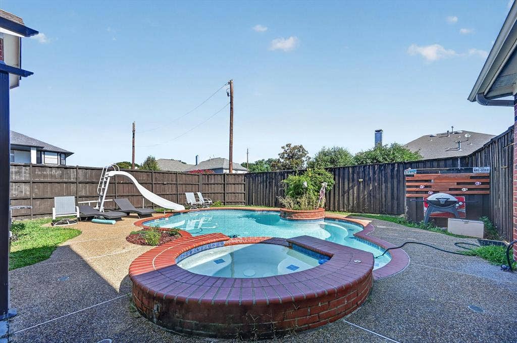 1625 Falmouth Drive, Plano, TX 75025 Outdoor living space featuring a freeform swimming pool and an integrated hot tub with brick surround