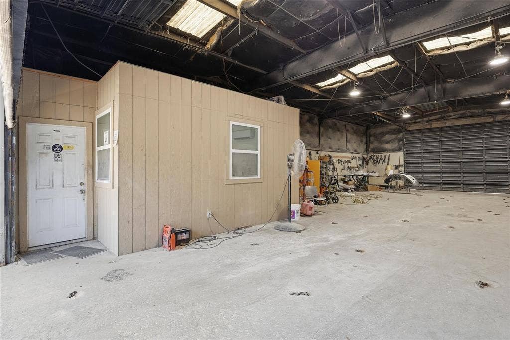 2136 California Crossing Road, Dallas, TX 75220 Spacious commercial interior featuring a built-in office structure with two windows and a white entry door