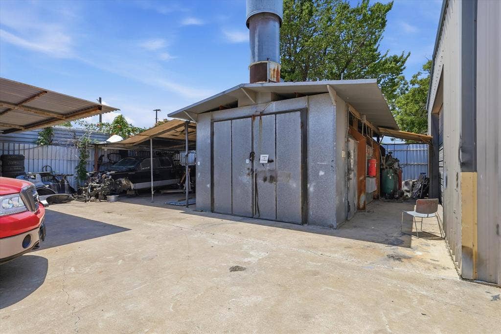 2136 California Crossing Road, Dallas, TX 75220 Industrial building featuring a tall exhaust stack, corrugated metal siding, and a concrete slab foundation