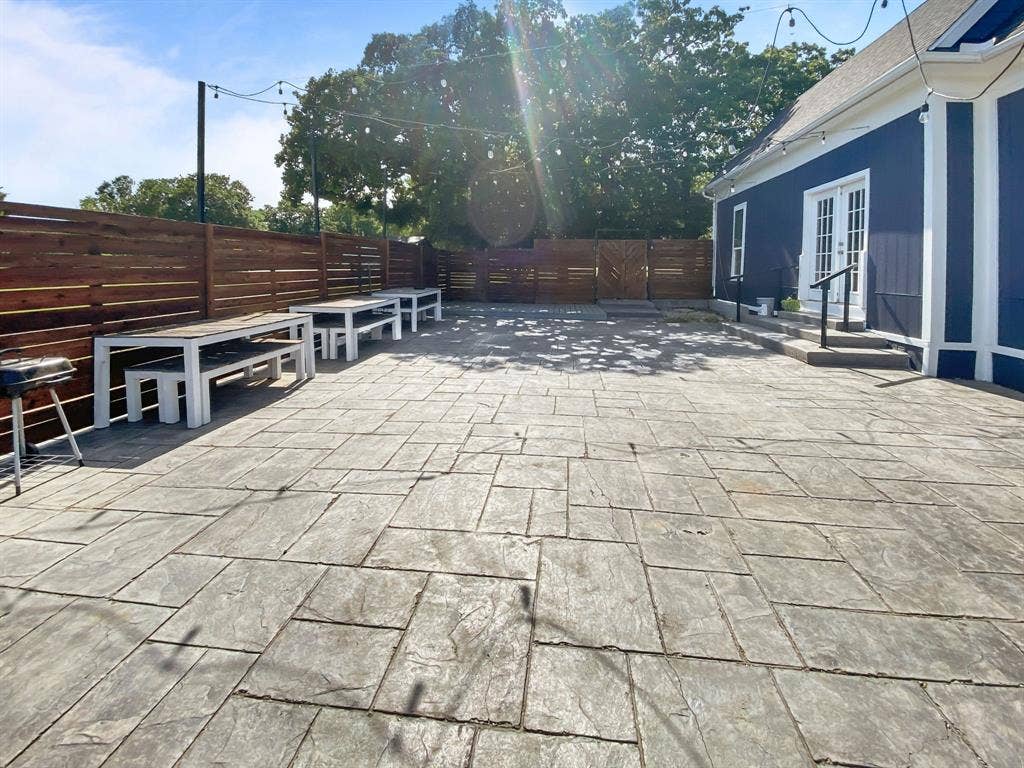 815 Stonecrest Road, Argyle, TX 76226 Expansive stamped concrete patio with a dark wood privacy fence, and a dark blue exterior with white trim