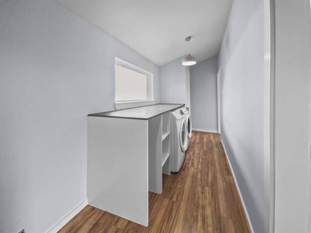 815 Stonecrest Road, Argyle, TX 76226 Laundry room featuring wood-finish flooring, a built-in countertop, a window, and a pendant light fixture