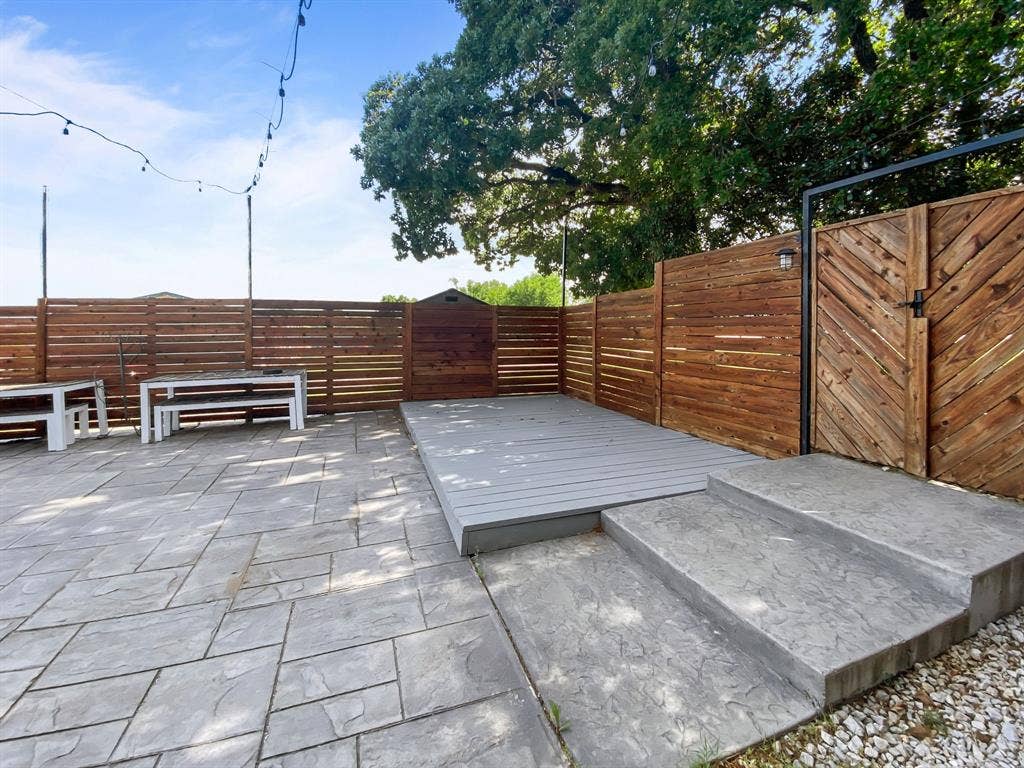 815 Stonecrest Road, Argyle, TX 76226 Stamped concrete patio with a raised composite deck, private wood fencing, and a wood gate with metal frame
