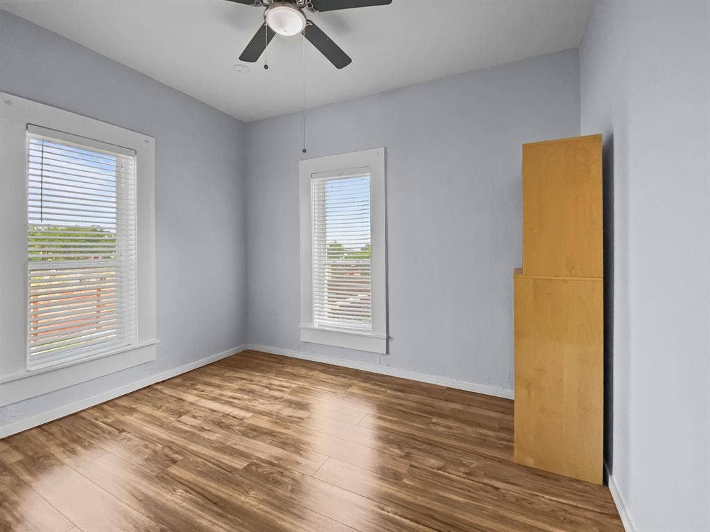 815 Stonecrest Road, Argyle, TX 76226 Wood-finish flooring, two windows with blinds, ceiling fan, and light blue wall color