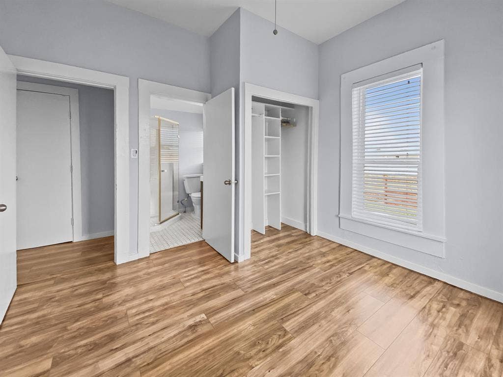 815 Stonecrest Road, Argyle, TX 76226 Wood-finish flooring throughout, light blue wall paint, white trim, and a window with blinds