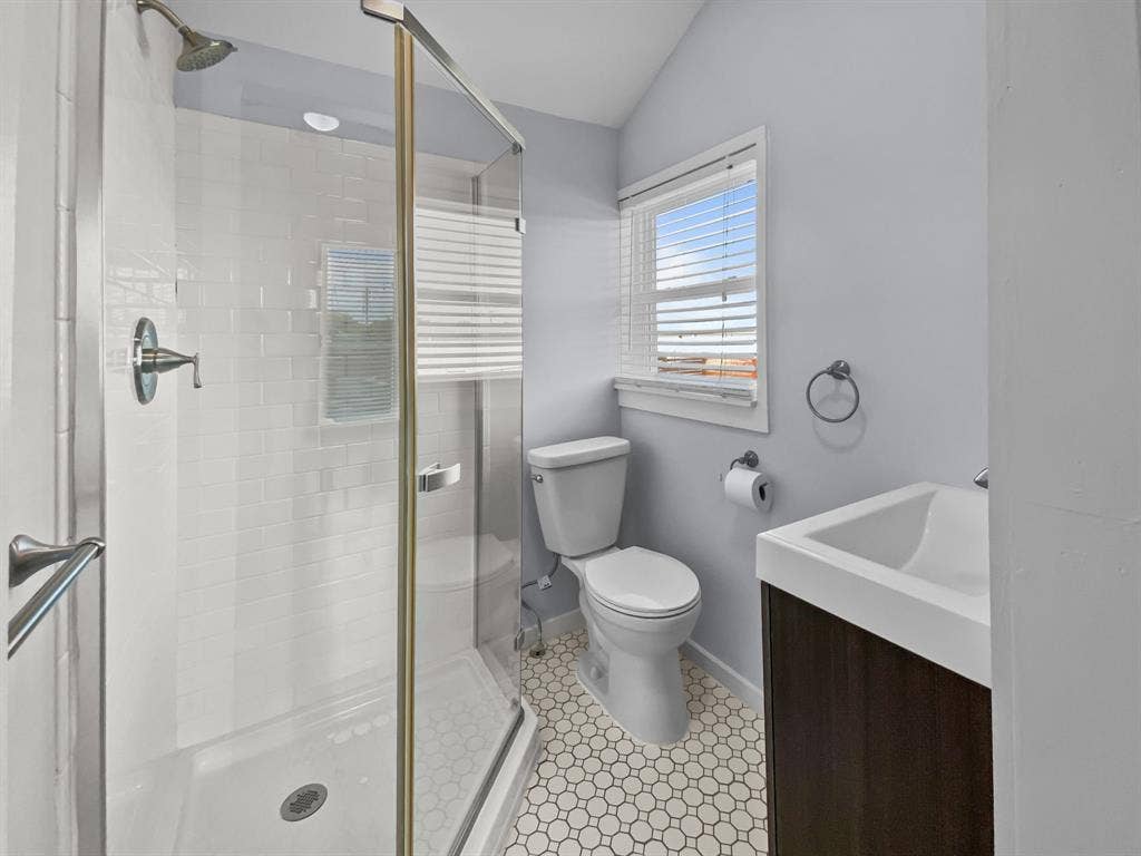 815 Stonecrest Road, Argyle, TX 76226 Glass-enclosed shower with subway tile surround, hexagonal tile flooring, and a modern vanity with integrated sink