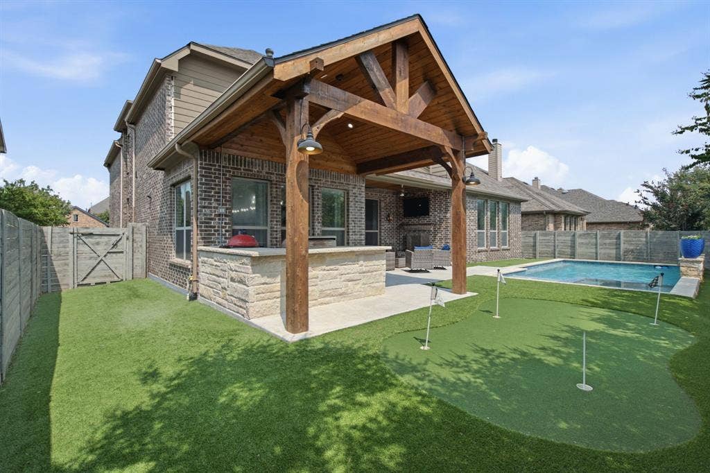 Covered extended patio with built in grill and bar space to dine