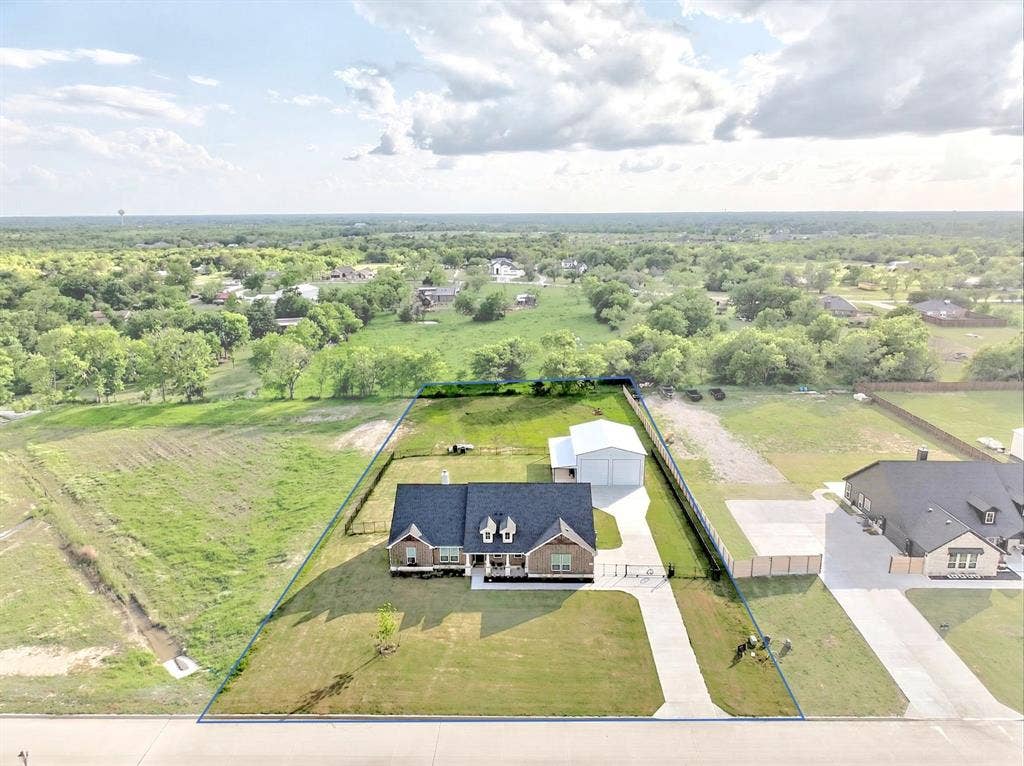2446 Blackjack Oak Road, Oak Ridge, TX 75161 Brick residence with a dark shingle roof and covered front porch