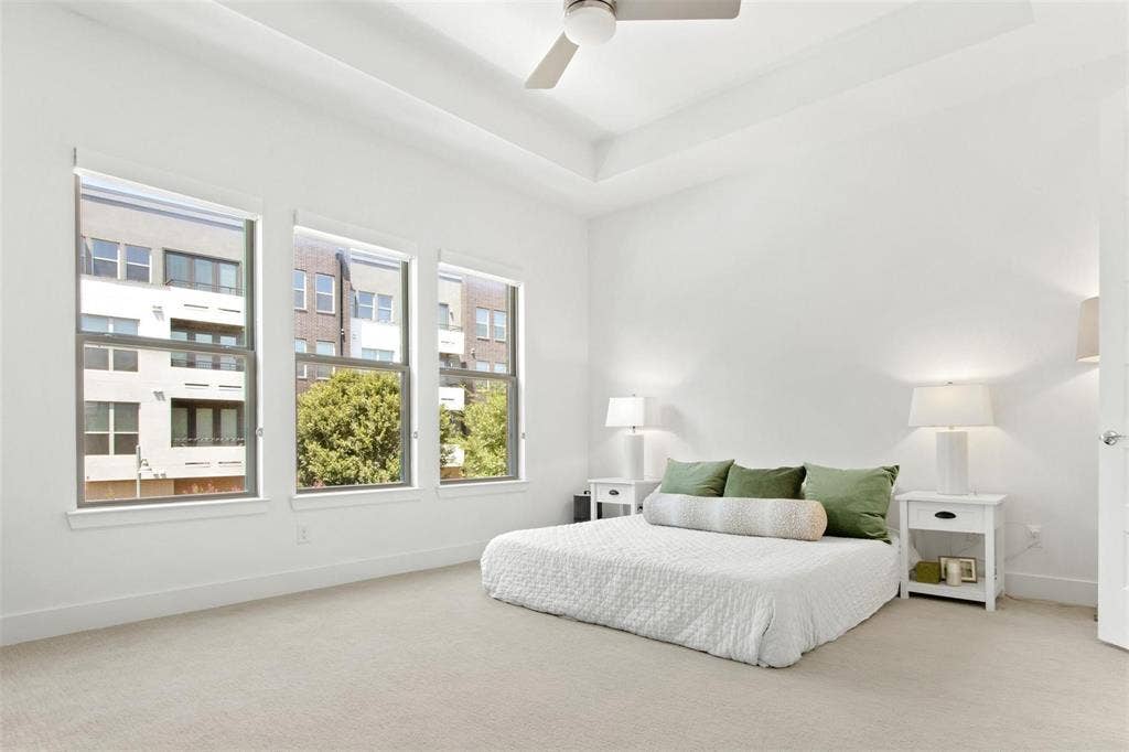 7867 Verona Place, Dallas, TX 75231 Bright room featuring three large windows, a tray ceiling, recessed lighting, a ceiling fan, and light-toned carpeting