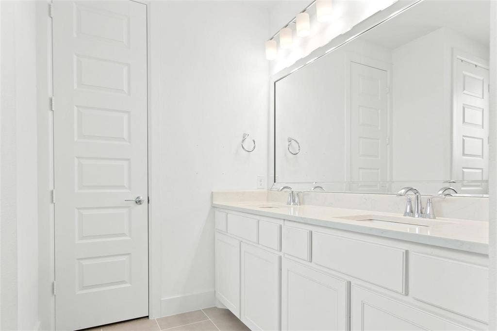 7867 Verona Place, Dallas, TX 75231 Dual vanity with white cabinetry, light-toned countertop, and chrome fixtures