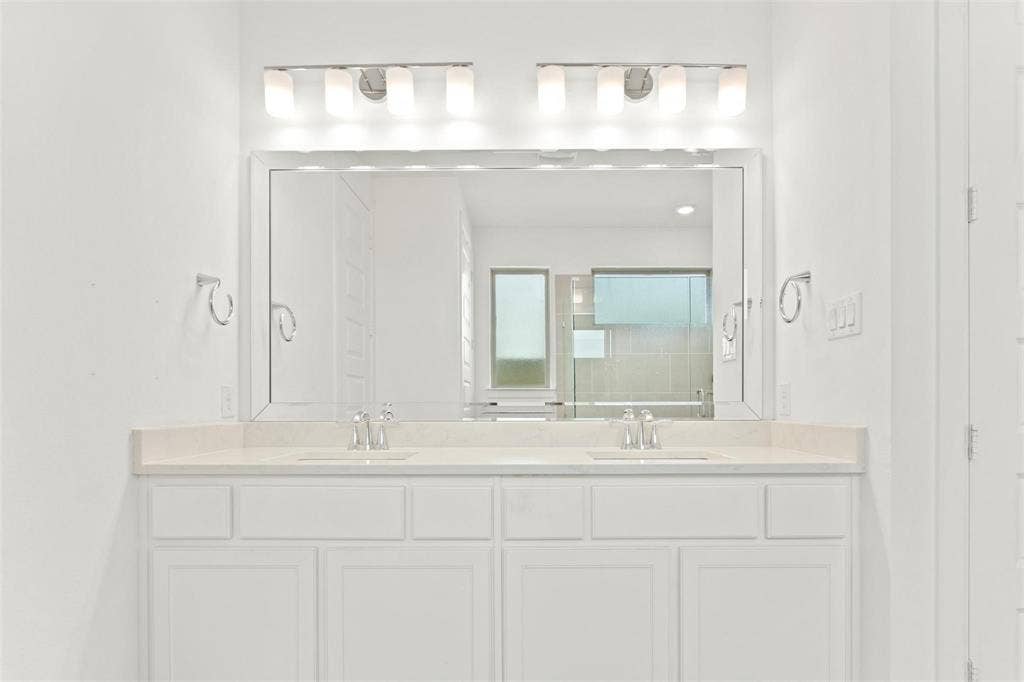 7867 Verona Place, Dallas, TX 75231 Dual vanity with white cabinetry, light-colored countertop, and two sets of chrome fixtures