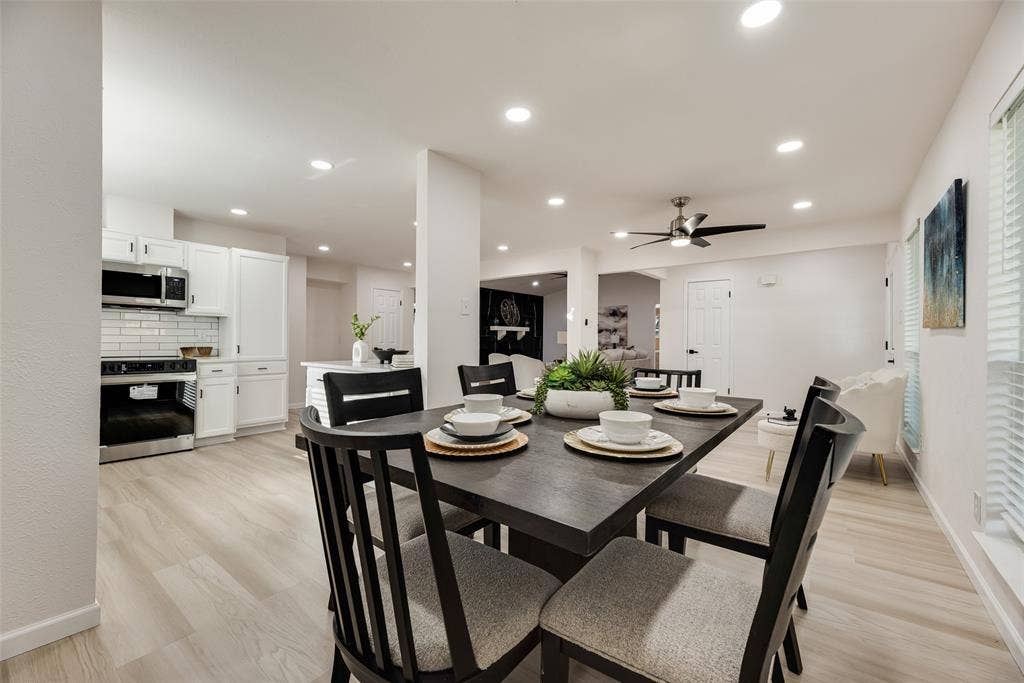 Open-concept dining area featuring light wood-finish flooring and recessed lighting