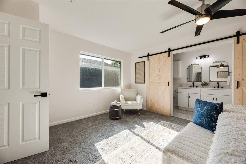 Bright interior space featuring light gray carpeting and a ceiling fan with integrated lighting