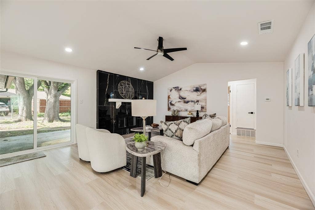 Living area featuring a vaulted ceiling and light wood-finish flooring
