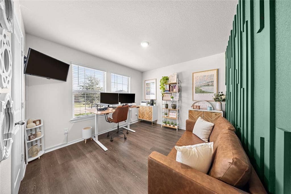 2920 Roper Street, Royse City, TX 75189 Interior room featuring dark wood-finish flooring, light-toned walls, and a distinctive green accent wall with a geometric pattern