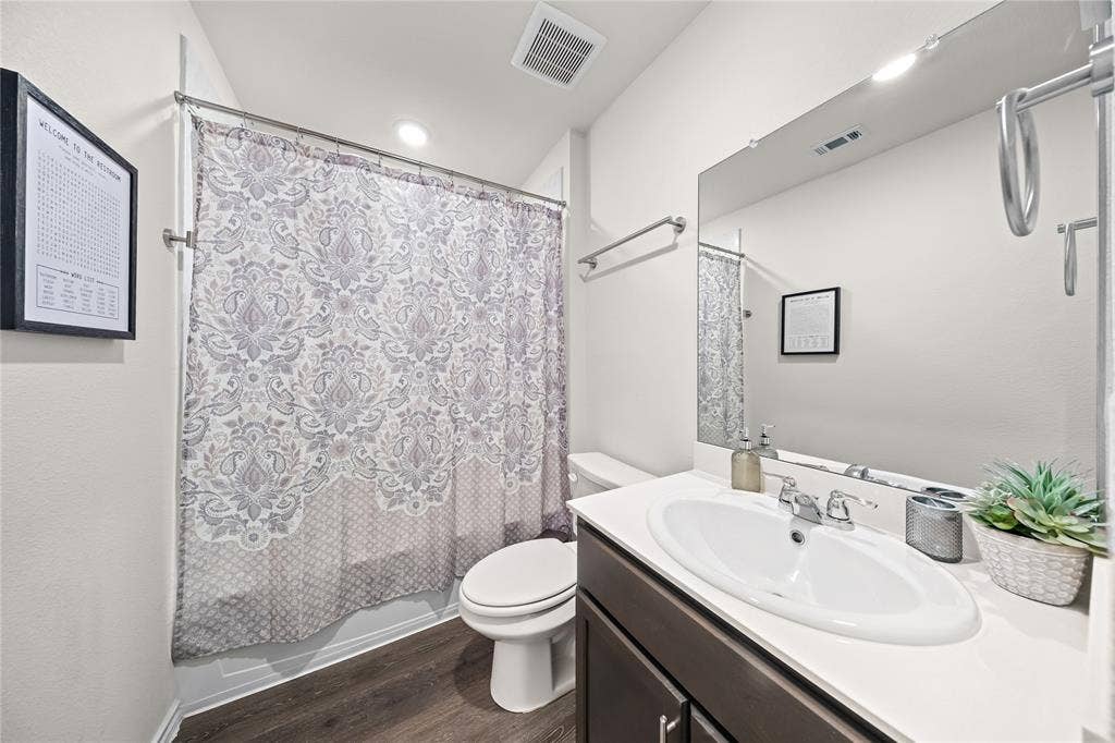 2920 Roper Street, Royse City, TX 75189 Bathroom featuring a dark wood-finish vanity, white countertop, oval undermount sink, and a framed mirror