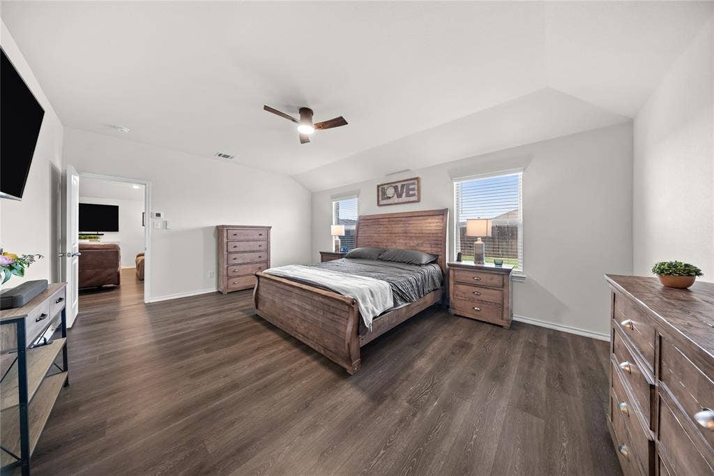 2920 Roper Street, Royse City, TX 75189 Spacious bedroom featuring dark wood-finish flooring, vaulted ceilings, and light-toned walls