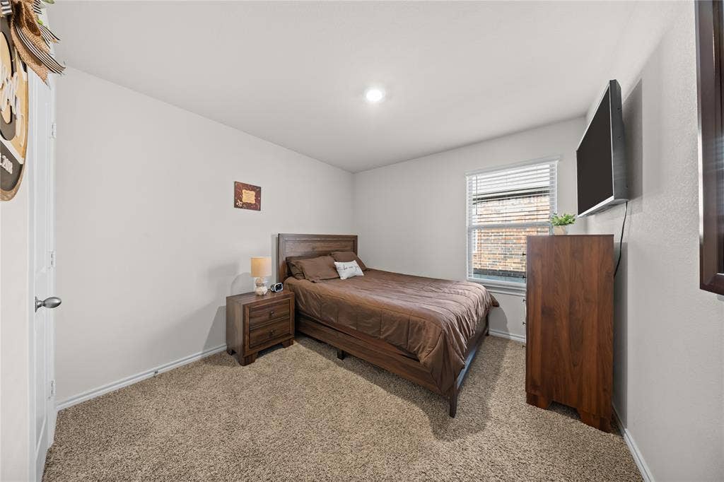 2920 Roper Street, Royse City, TX 75189 Bedroom featuring neutral wall paint, textured carpeting, a single window with horizontal blinds, and a recessed ceiling light