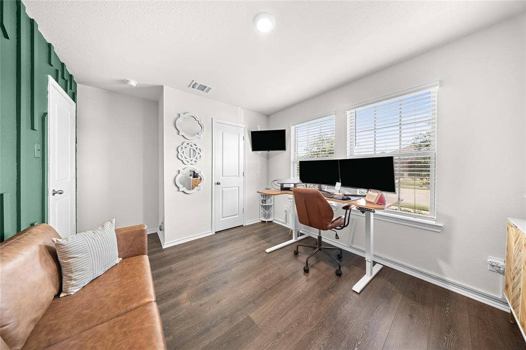 2920 Roper Street, Royse City, TX 75189 Versatile room featuring dark wood-finish flooring and a distinctive accent wall with vertical paneling