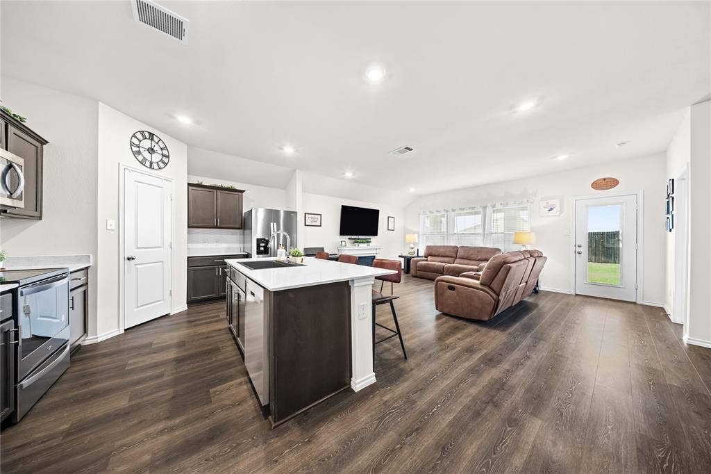 2920 Roper Street, Royse City, TX 75189 Open-concept living space featuring wood-finish flooring, recessed lighting, and white walls