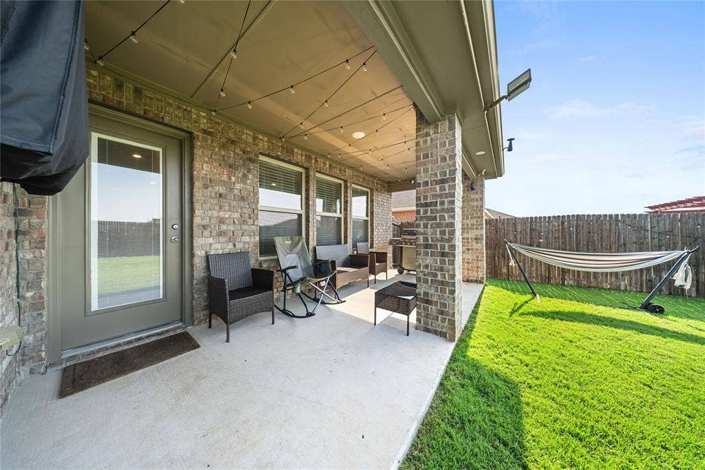 2920 Roper Street, Royse City, TX 75189 Covered patio featuring string lighting, brick columns, and a concrete surface