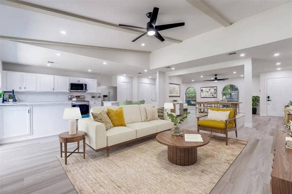 Open-concept living space featuring a cream upholstered sofa, wood-finish flooring throughout, and recessed ceiling lighting