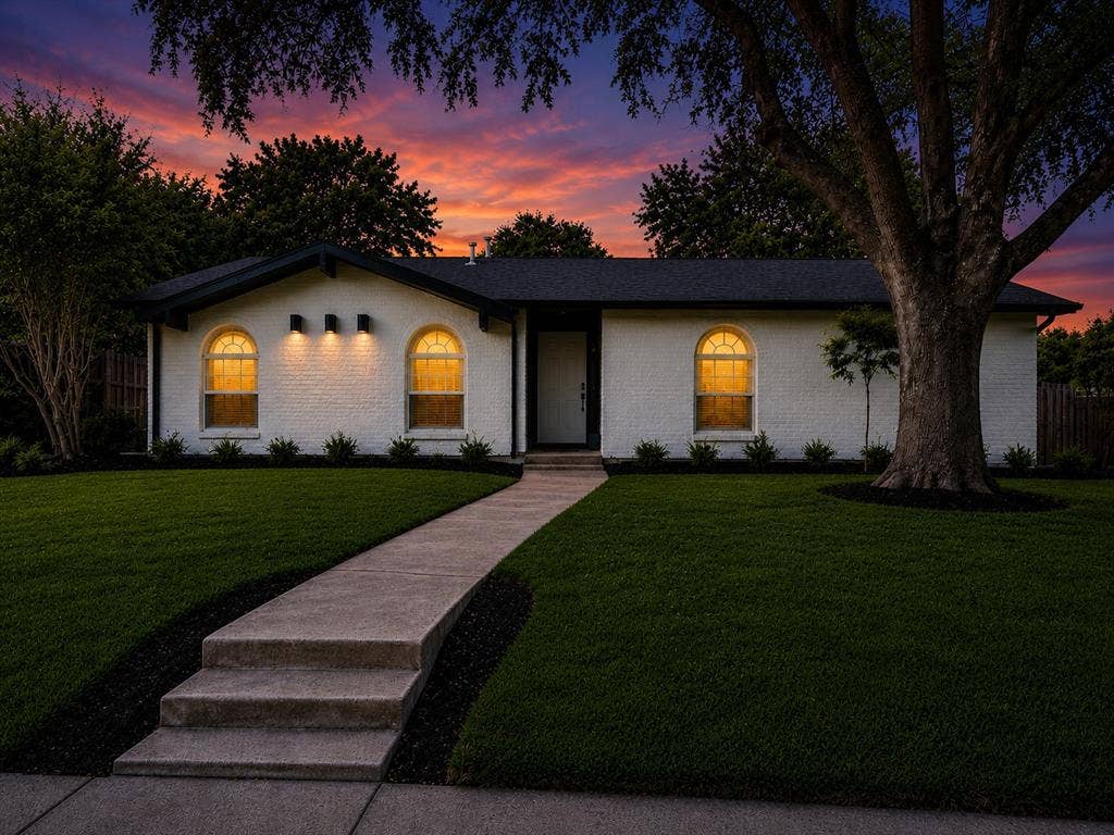 Modern single-story residence featuring a clean-lined white exterior with arched entry doors and transom windows