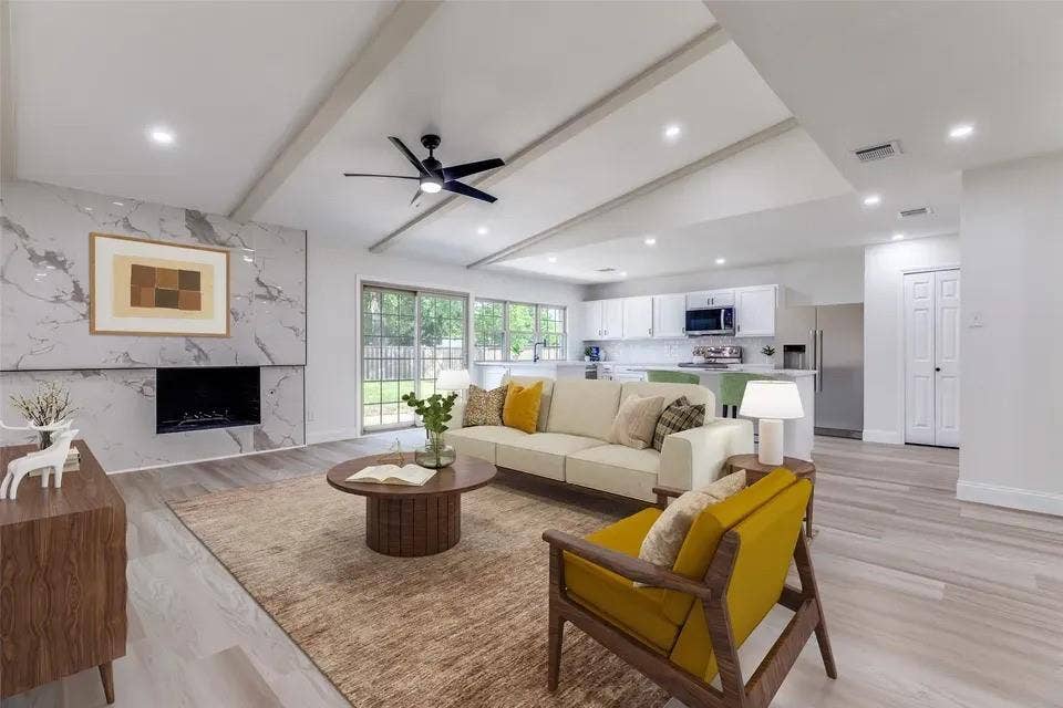 Spacious living area featuring a vaulted ceiling with exposed beams, recessed lighting, and wood-finish flooring