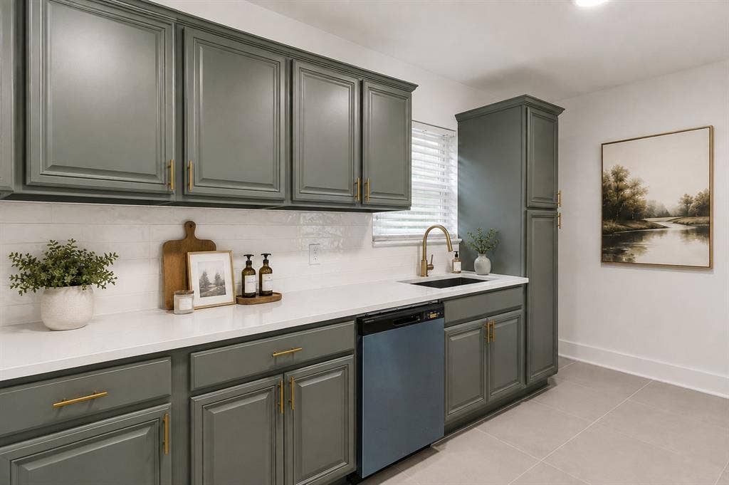 2251 Hartline Drive, Dallas, TX 75228 Designed with timeless elegance and everyday functionality, this beautiful updated kitchen showcases custom sage-green shaker cabinetry accented with brushed brass hardware sleek quartz countertops, and a classic white subway title backsplash. A spacious workstation provides generous prep space, while the premium stainless steel dishwasher, designer brushed gold faucet, and oversized pantry cabinet add both style and practicality