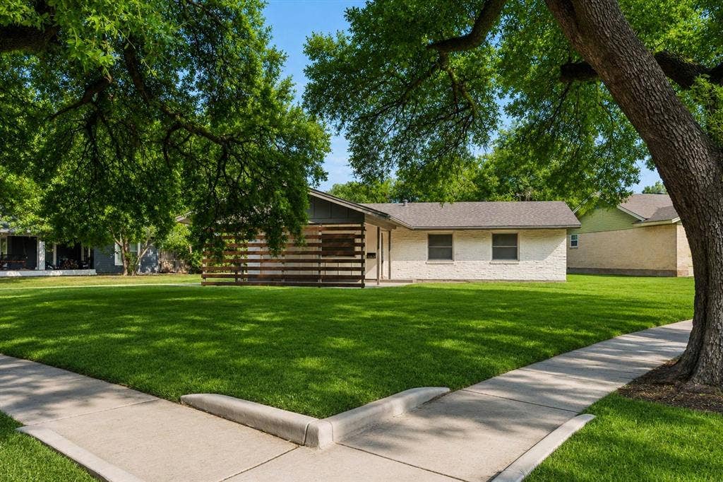 2251 Hartline Drive, Dallas, TX 75228 Welcome home to timeless charm and exceptional curb appeal. Framed by majestic, mature shade trees, this thoughtfully renovated residence makes an unforgettable first impression. The modern horizontal wood privacy screen adds architectural character, while the crisp painted brick exterior and inviting front entrance create a warm, sophisticated aesthetic. Set on a spacious corner lot, the property offers both beauty and functionality, with expansive green space perfect for outdoor enjoyment and mature trees that provide shade and enhance the peaceful setting. Blending contemporary updates with classic charm, this home is nestled in an established neighborhood where pride of ownership is evident offering the perfect balance of comfort, style, and tranquility