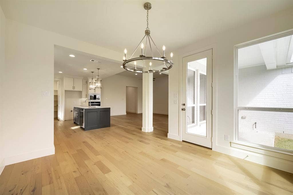 690 Red Cedar Road, Haslet, TX 76052 Light wood-finish flooring with a modern chandelier, white trim, and a glass-paneled door