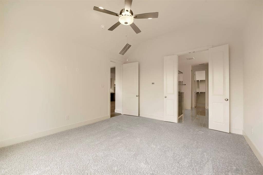 690 Red Cedar Road, Haslet, TX 76052 Vaulted ceiling, ceiling fan with integrated lighting, neutral carpeting, white interior doors, and custom built-in shelving