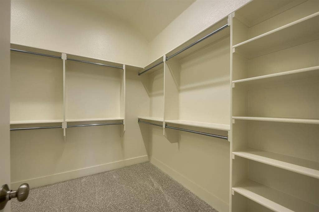 690 Red Cedar Road, Haslet, TX 76052 Integrated shelving system, multiple hanging rods, built-in storage, and carpet flooring