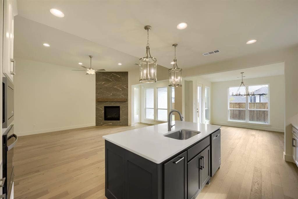 690 Red Cedar Road, Haslet, TX 76052 Kitchen island with a built-in sink and pendant lighting